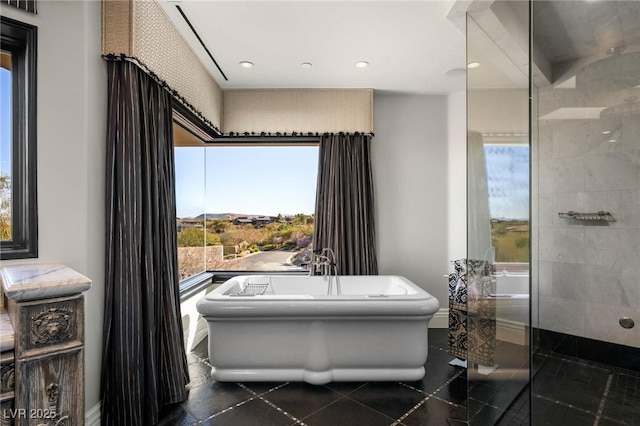 bathroom with a soaking tub, recessed lighting, and tiled shower