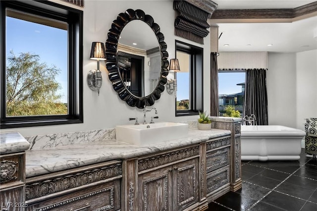 full bathroom with a wealth of natural light, a freestanding bath, vanity, and tile patterned flooring