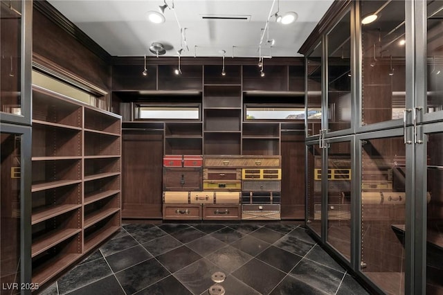 walk in closet with dark tile patterned floors