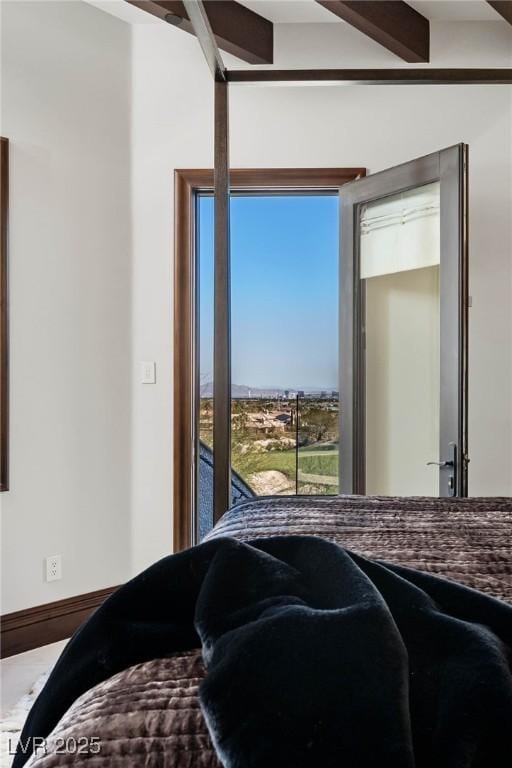 bedroom featuring beamed ceiling and baseboards