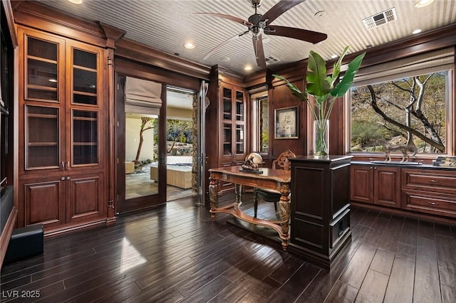 home office with visible vents, dark wood-style flooring, a ceiling fan, and ornamental molding