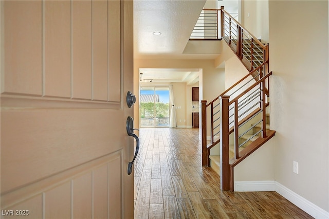 entryway featuring stairway, baseboards, and wood finished floors