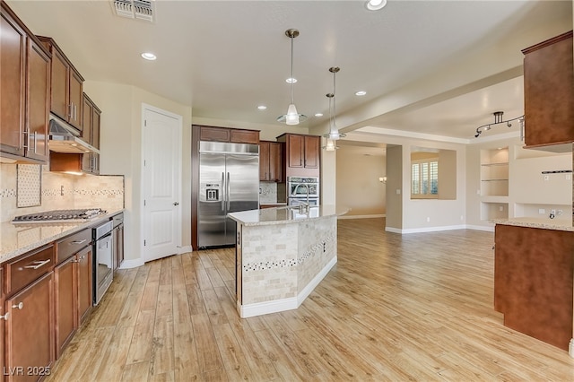 kitchen with under cabinet range hood, visible vents, appliances with stainless steel finishes, and light wood-type flooring