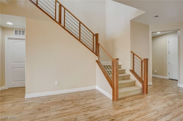 staircase with recessed lighting, wood finished floors, visible vents, and baseboards