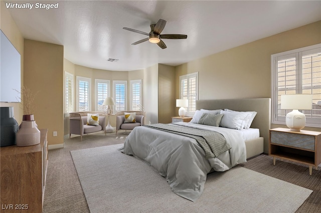 carpeted bedroom featuring visible vents, a ceiling fan, and baseboards