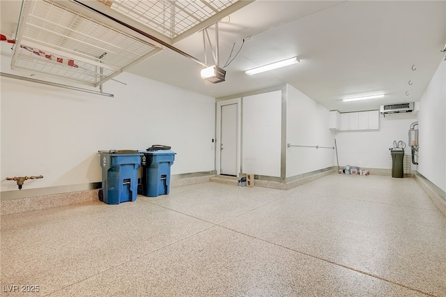 garage featuring baseboards, an AC wall unit, a garage door opener, and water heater