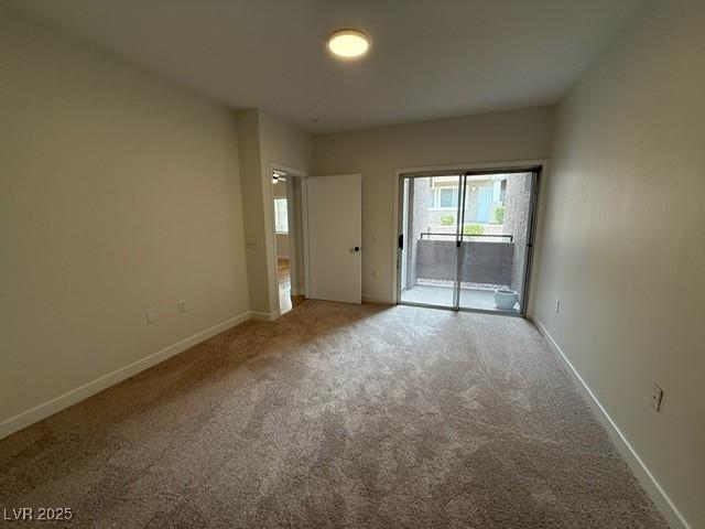 carpeted spare room featuring baseboards