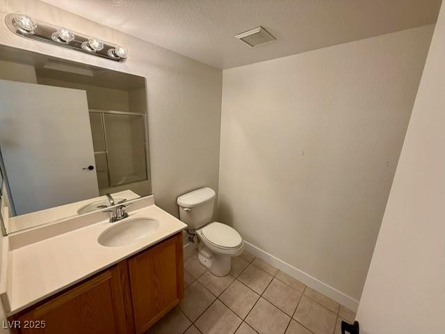 full bath with vanity, a shower with shower door, a textured ceiling, tile patterned floors, and toilet