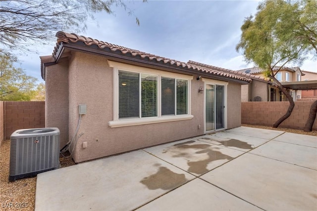 back of property with a patio, central air condition unit, and stucco siding