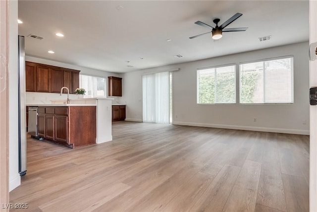 kitchen with light countertops, open floor plan, light wood-style flooring, and visible vents