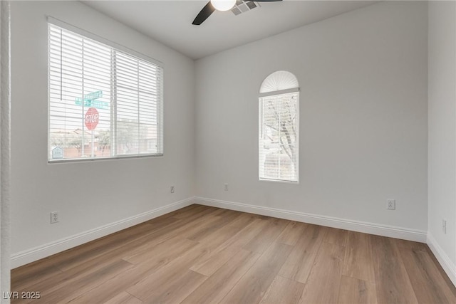 spare room featuring visible vents, baseboards, a ceiling fan, and light wood finished floors