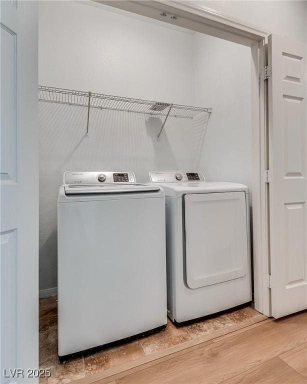 laundry room with laundry area, light wood-style flooring, and washing machine and clothes dryer