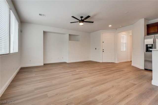 unfurnished living room featuring light wood-style flooring, baseboards, visible vents, and ceiling fan