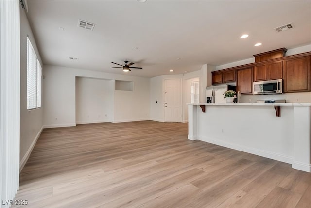 kitchen with light countertops, a breakfast bar area, visible vents, and appliances with stainless steel finishes