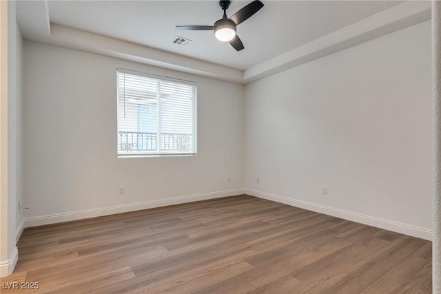 unfurnished room featuring visible vents, baseboards, a ceiling fan, and light wood finished floors