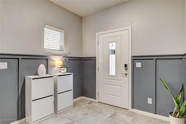 entrance foyer featuring a wainscoted wall and a decorative wall