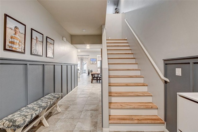 staircase with tile patterned flooring and a decorative wall