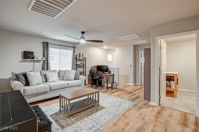 living room with visible vents, light wood-style flooring, and ceiling fan