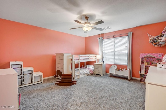 carpeted bedroom with visible vents, baseboards, and a ceiling fan