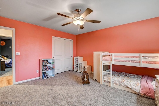 carpeted bedroom featuring a closet, baseboards, and a ceiling fan