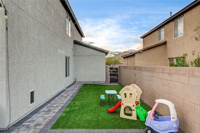 view of yard featuring a gate, a playground, and fence