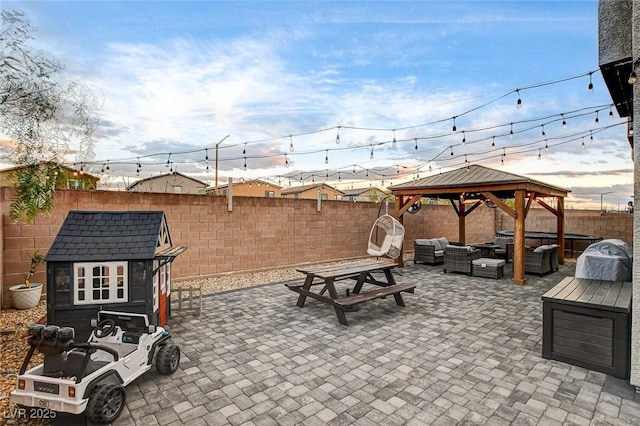 view of patio with an outbuilding, an outdoor living space, a fenced backyard, a gazebo, and a storage shed