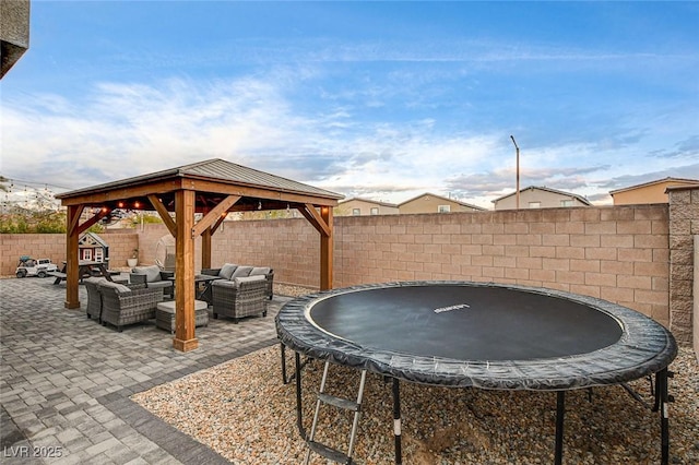 view of patio featuring a fenced backyard, an outdoor living space, a gazebo, and a trampoline