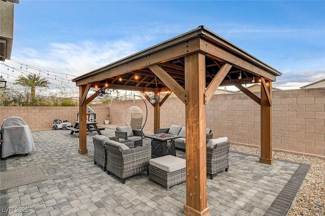 view of patio with a gazebo, a fenced backyard, and an outdoor fire pit