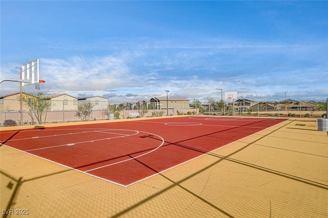 view of basketball court featuring a residential view, community basketball court, and fence