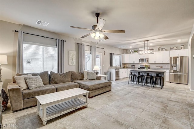 living room featuring visible vents and ceiling fan