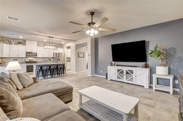 living area featuring recessed lighting, visible vents, baseboards, and ceiling fan