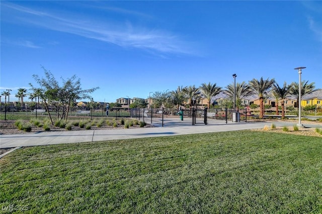 view of property's community with a gate, a lawn, and fence