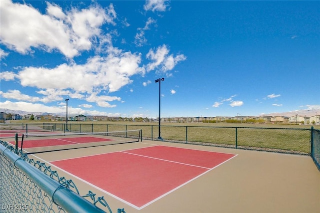 view of tennis court with community basketball court and fence