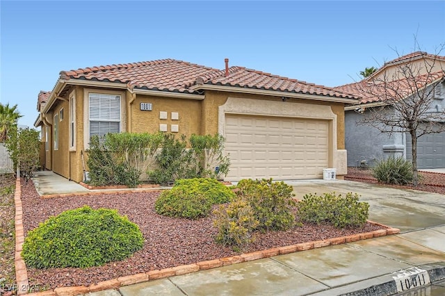 mediterranean / spanish house with stucco siding, a tiled roof, concrete driveway, and an attached garage