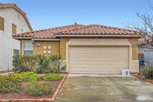 mediterranean / spanish house with concrete driveway, a garage, a tile roof, and stucco siding