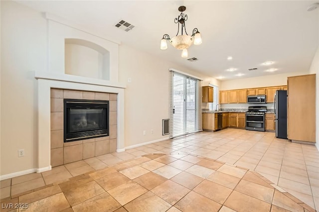 kitchen featuring visible vents, pendant lighting, stainless steel appliances, light tile patterned flooring, and baseboards