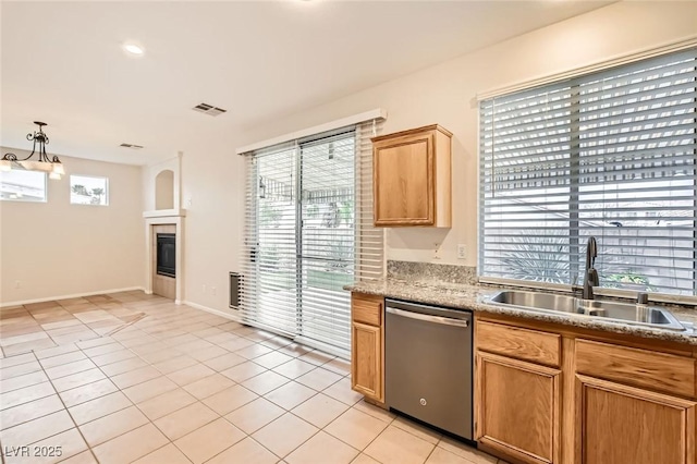 kitchen featuring visible vents, a tiled fireplace, a sink, stainless steel dishwasher, and light tile patterned floors