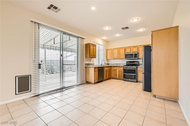 kitchen with a sink, baseboards, visible vents, and stainless steel appliances