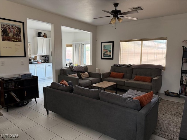 living room featuring a ceiling fan and visible vents