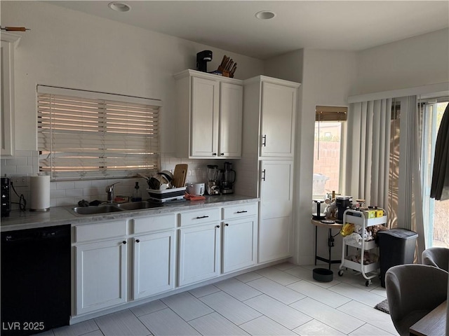 kitchen featuring backsplash, white cabinetry, black dishwasher, and a sink