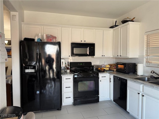 kitchen featuring a sink, tasteful backsplash, black appliances, and white cabinets