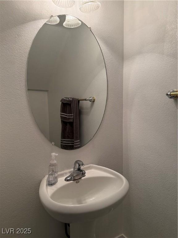 bathroom with a textured wall and a sink