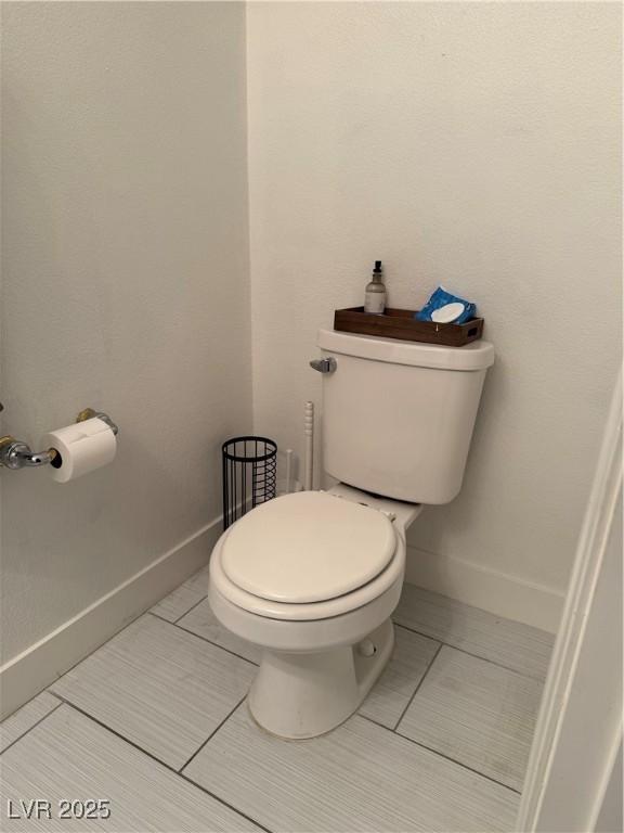 bathroom featuring toilet and baseboards