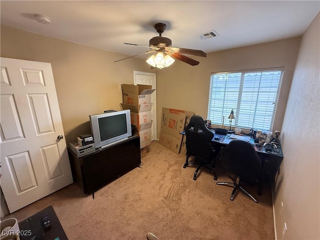 office space with ceiling fan, visible vents, and light carpet