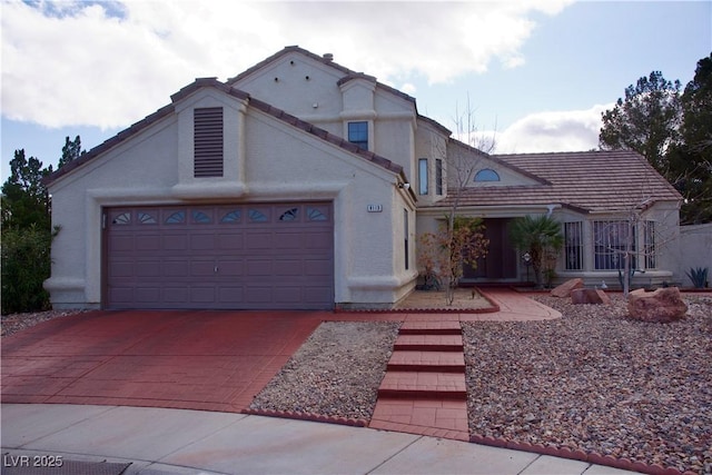 view of front of property featuring a tiled roof, stucco siding, driveway, and a garage