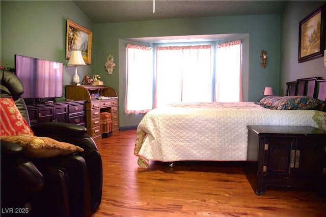 bedroom featuring vaulted ceiling and wood finished floors