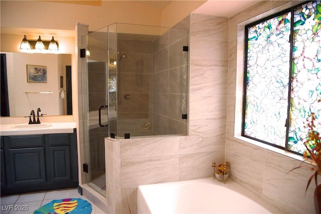 bathroom with vanity, a shower stall, a garden tub, and tile patterned floors