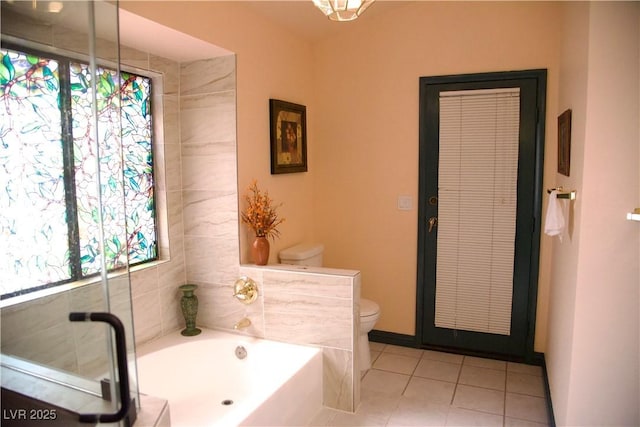 bathroom featuring tile patterned floors, toilet, and a garden tub