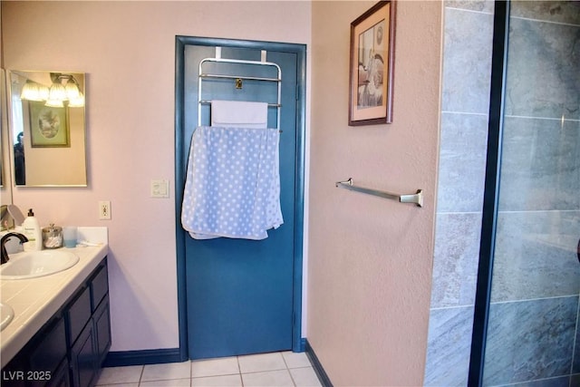 bathroom featuring tile patterned flooring, double vanity, baseboards, and a sink