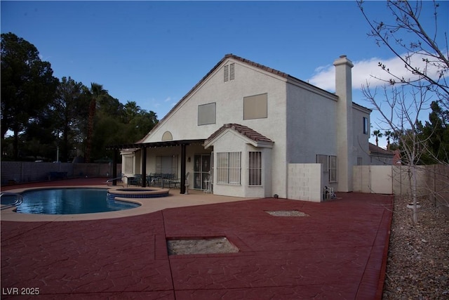 rear view of property with a patio area, a fenced backyard, a chimney, and stucco siding